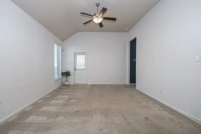an empty room with fan and windows