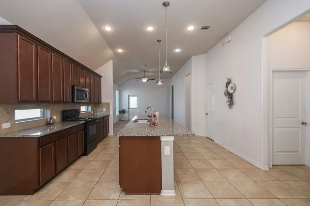 a large kitchen with stainless steel appliances lots of counter top space