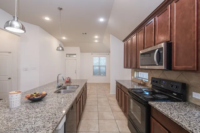 a kitchen with sink stove and cabinets