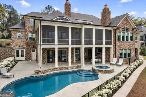 a front view of a house with swimming pool and outdoor seating