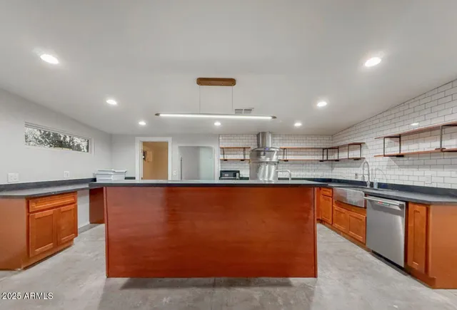 a large kitchen with stainless steel appliances granite countertop a sink and cabinets