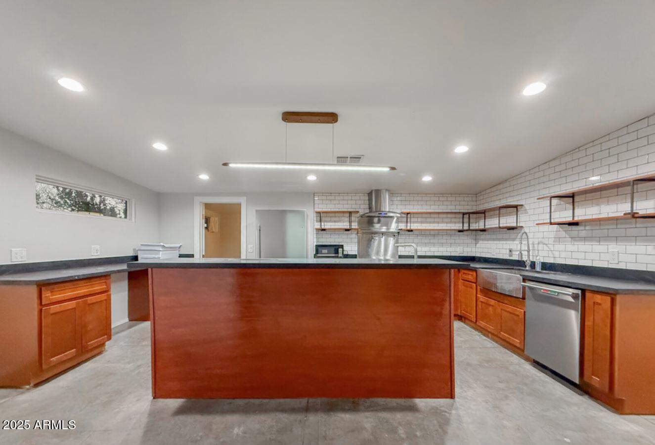 a large kitchen with stainless steel appliances granite countertop a sink and cabinets