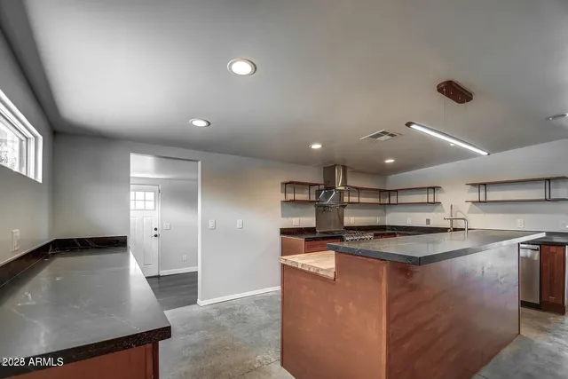 a large kitchen with stainless steel appliances granite countertop a sink and cabinets