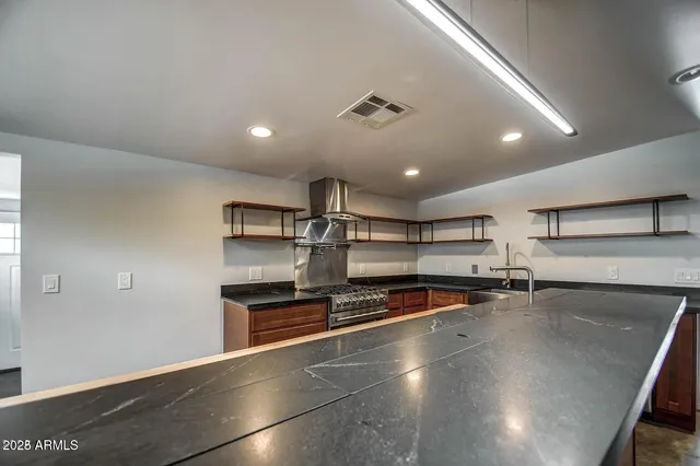 a large kitchen with stainless steel appliances a large counter top