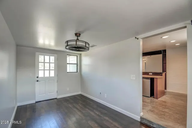 an empty room with wooden floor and ceiling fan