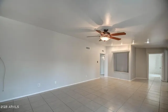 a view of a hallway with a chandelier fan and windows