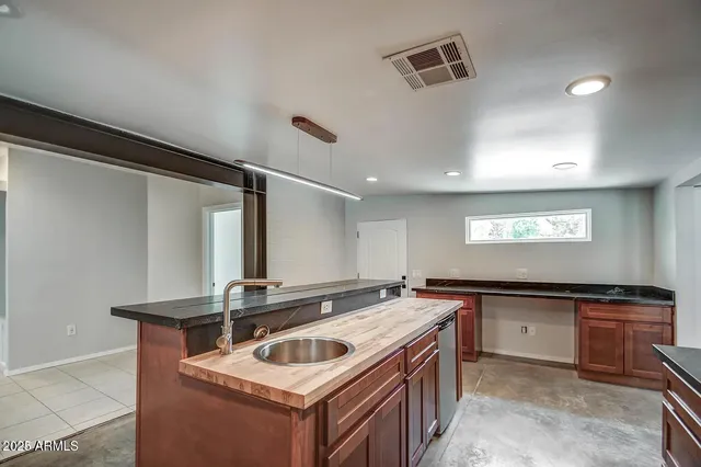 a kitchen with stainless steel appliances granite countertop a sink a stove and a refrigerator