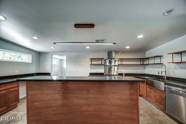 a kitchen with stainless steel appliances granite countertop a sink and stove