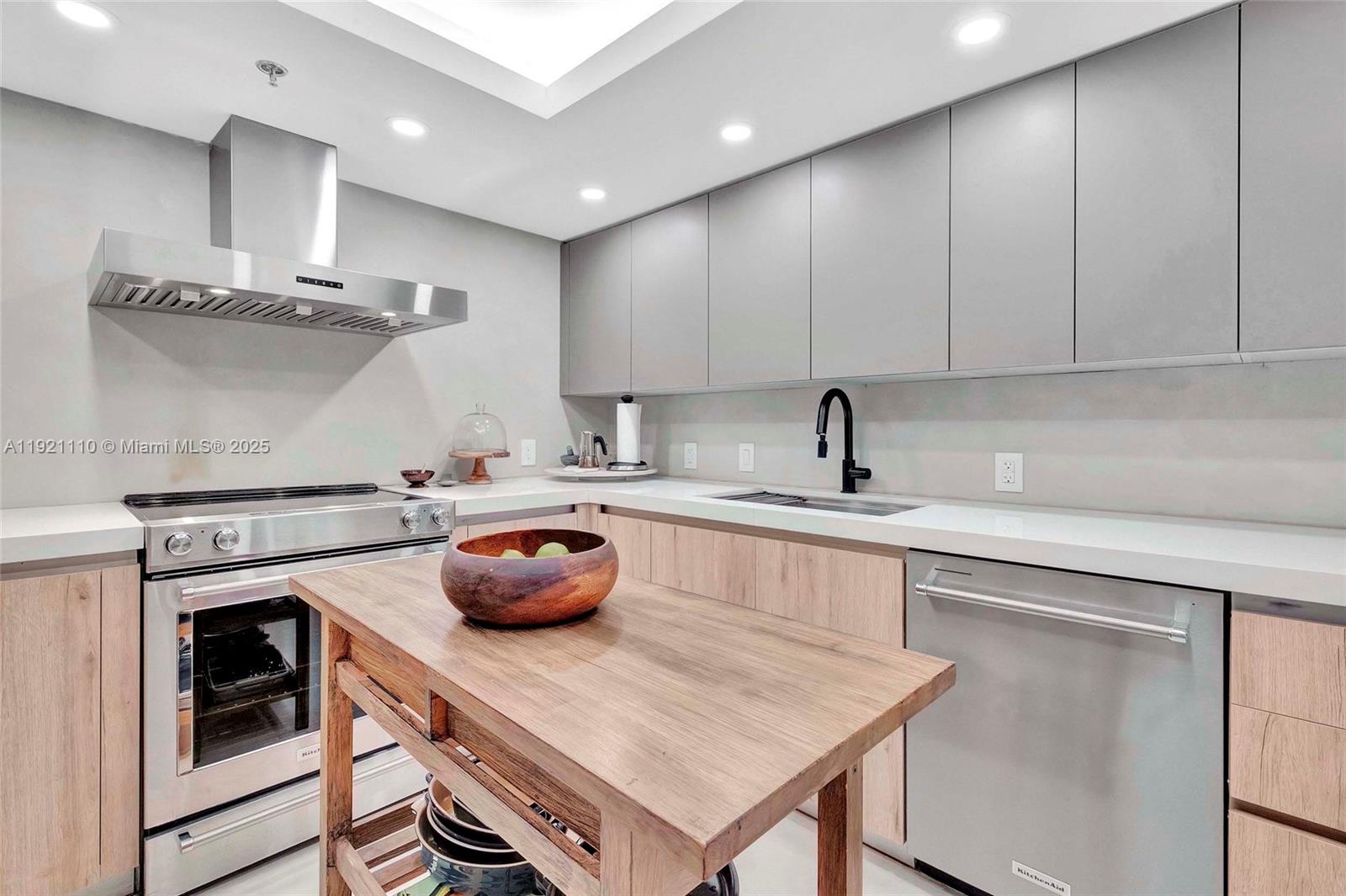 1627 Brickell Avenue, Unit 1202 Miami, FL 33129 - Photo 11 of 30 a kitchen with a sink a stove and cabinets