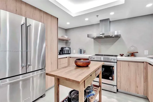 a kitchen with stainless steel appliances a stove a refrigerator and wooden cabinets