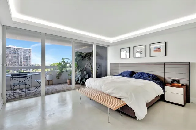 a spacious bedroom with a bed a table and chair