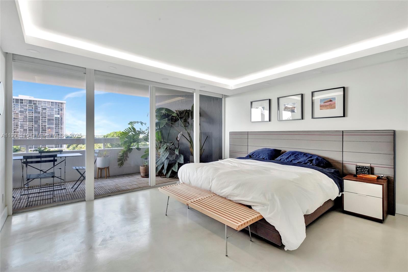 1627 Brickell Avenue, Unit 1202 Miami, FL 33129 - Photo 15 of 30 a spacious bedroom with a bed a table and chair