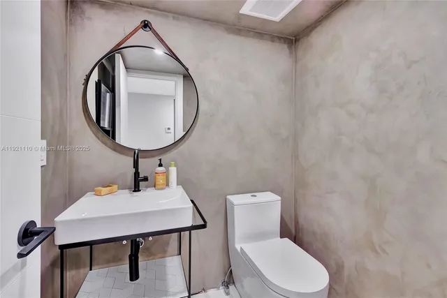 a bathroom with a toilet a sink and a mirror