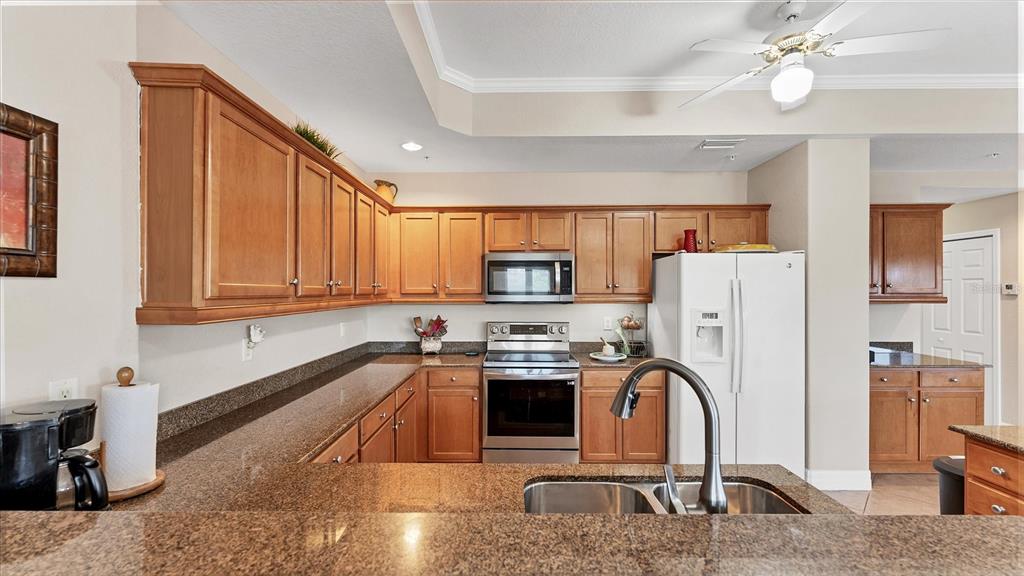 2245 North Beach Road, Unit 203 Englewood, FL 34223 - Photo 13 of 55 a kitchen with stainless steel appliances granite countertop a refrigerator a sink dishwasher a stove and a dining table with wooden floor
