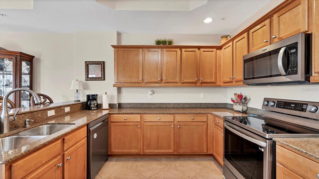2245 North Beach Road, Unit 203 Englewood, FL 34223 - Photo 14 of 55 a kitchen with stainless steel appliances granite countertop a sink stove and microwave