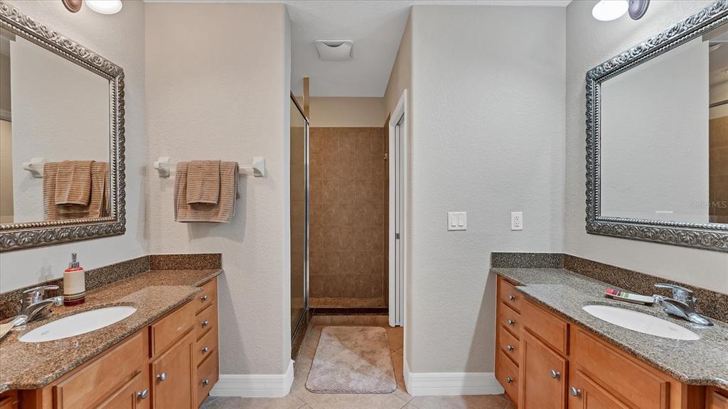 2245 North Beach Road, Unit 203 Englewood, FL 34223 - Photo 21 of 55 a bathroom with a granite countertop double vanity sink and mirror