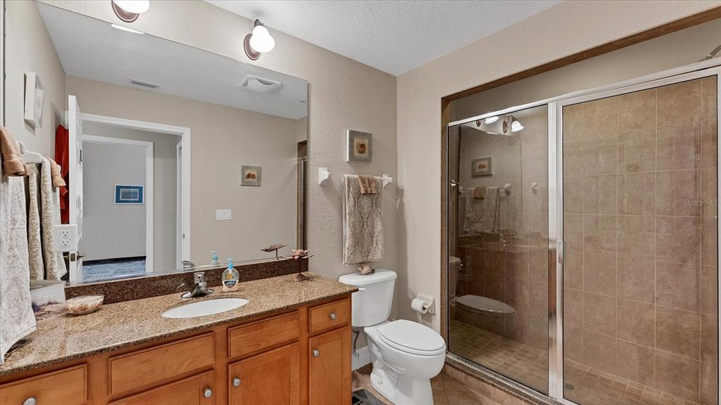 2245 North Beach Road, Unit 203 Englewood, FL 34223 - Photo 25 of 55 a bathroom with a granite countertop sink toilet mirror and shower