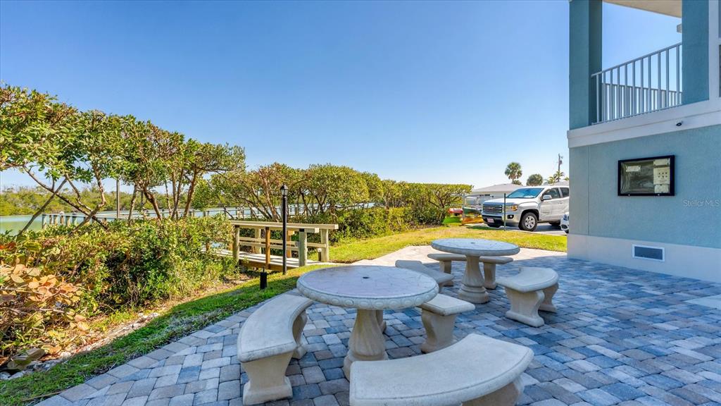 2245 North Beach Road, Unit 203 Englewood, FL 34223 - Photo 33 of 55 a view of a chairs and table in backyard