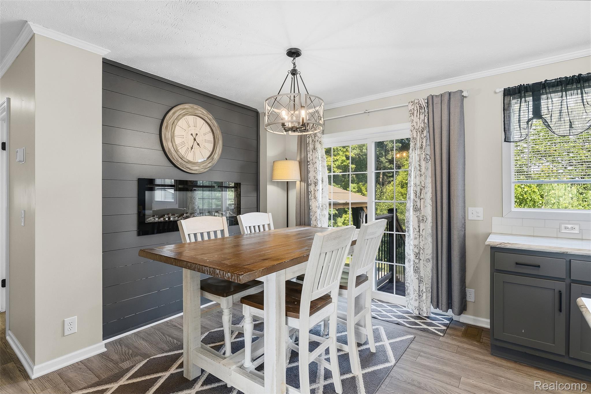 6450 Prince Boulevard Fenton, MI 48430 - Photo 18 of 31 Dining area featuring a built-in electric fireplace, shiplap accent wall, and wood-finish flooring