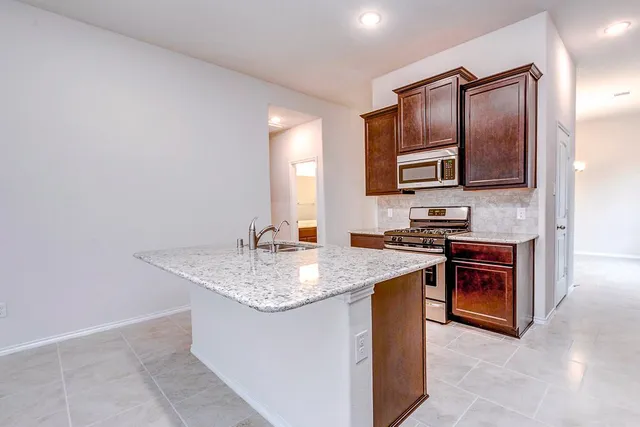 a kitchen with stainless steel appliances granite countertop a sink stove and oven