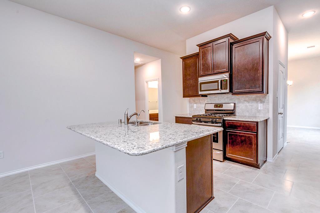 24314 North Newcastle Bay Trail Spring, TX 77389 - Photo 13 of 32 a kitchen with stainless steel appliances granite countertop a sink stove and oven