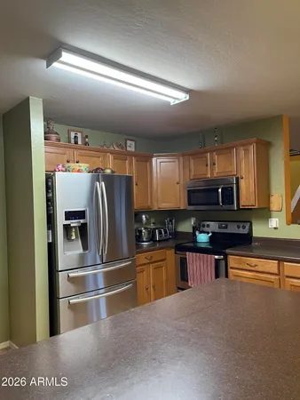 a kitchen with stainless steel appliances granite countertop a refrigerator a stove and a sink