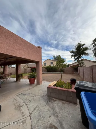 a backyard of a house with barbeque oven and outdoor seating