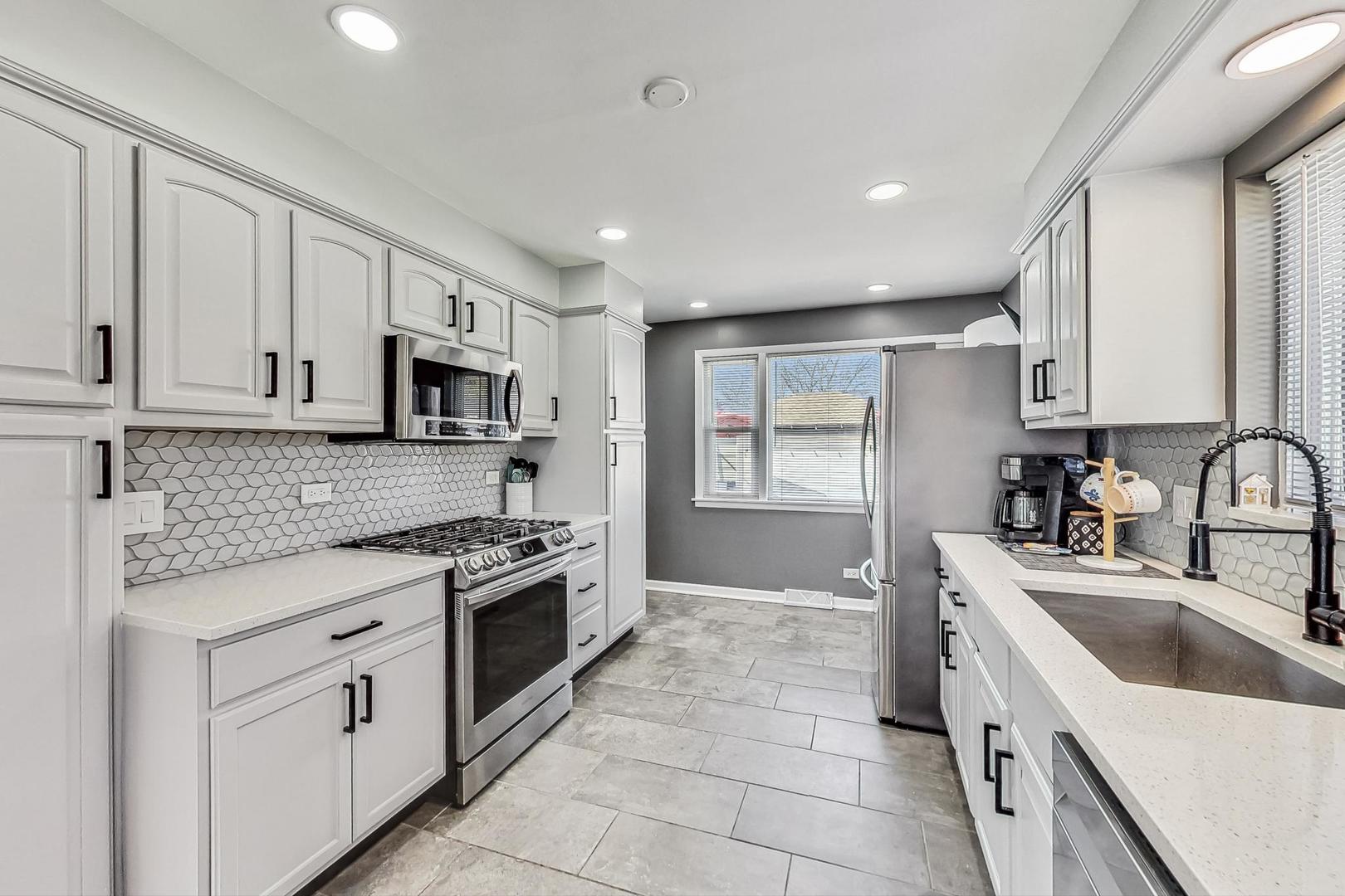 824 Florence Drive Park Ridge, IL 60068 - Photo 9 of 45 a kitchen with white cabinets stainless steel appliances and a window