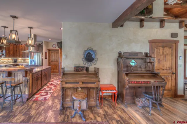 a open kitchen with stainless steel appliances kitchen island granite countertop a stove a refrigerator a dining table and chairs with wooden floor