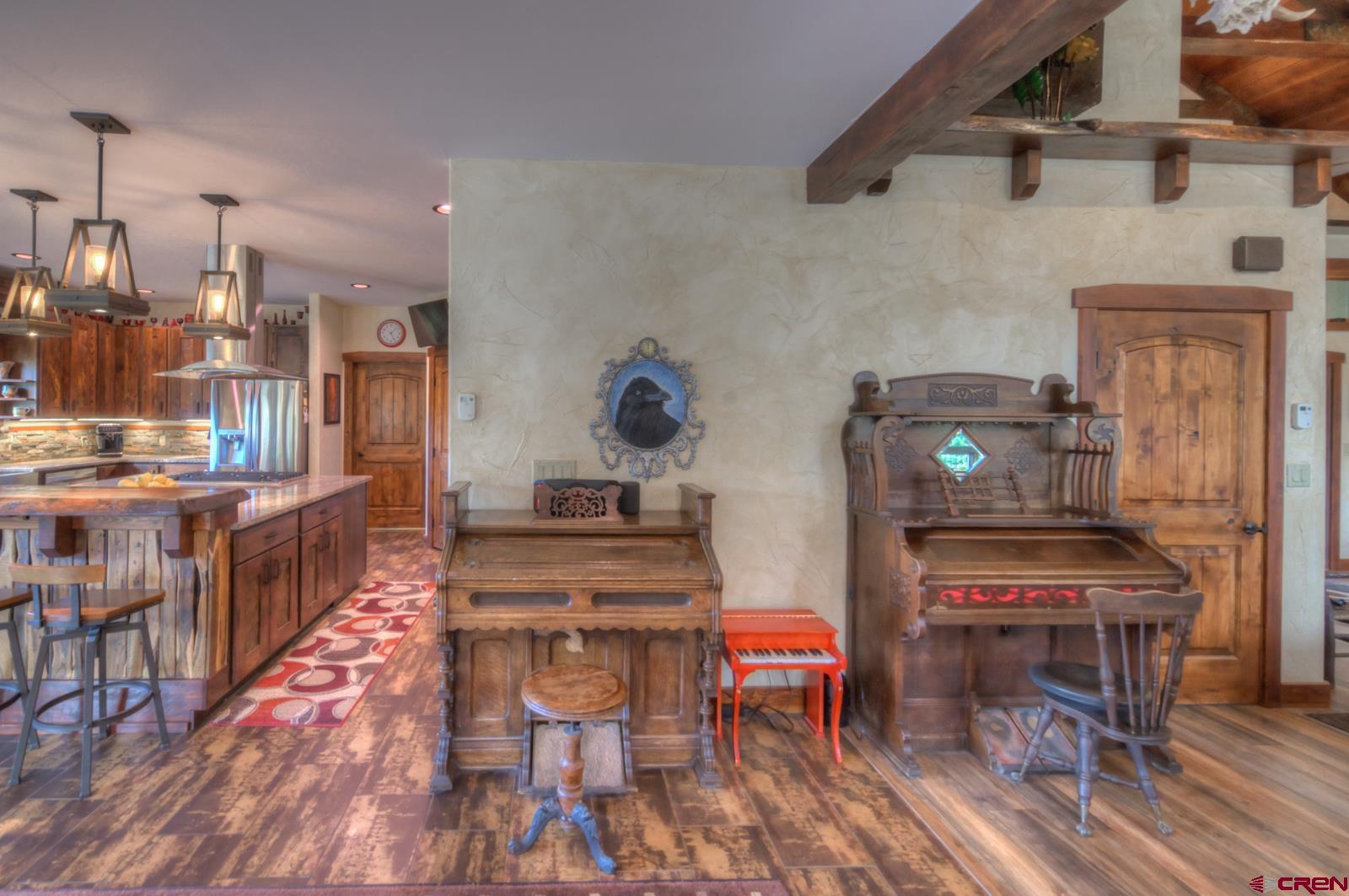 1833 Yellowstone Creek Road Walsenburg, CO 81089 - Photo 11 of 44 a open kitchen with stainless steel appliances kitchen island granite countertop a stove a refrigerator a dining table and chairs with wooden floor