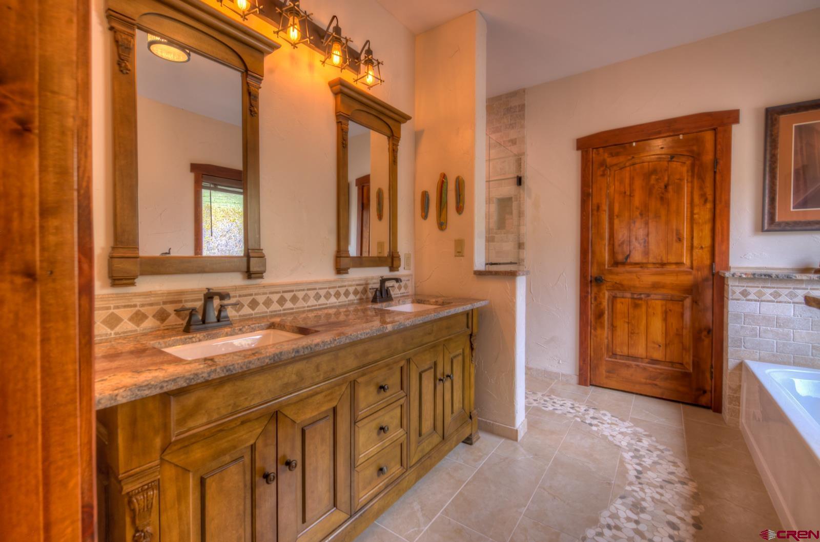 1833 Yellowstone Creek Road Walsenburg, CO 81089 - Photo 26 of 44 a bathroom with a double vanity sink and a mirror