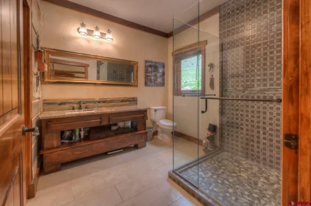 a bathroom with a granite countertop sink a toilet and shower