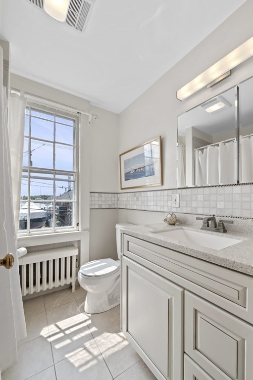 80 Front Street Marblehead, MA 01945 - Photo 28 of 42 a bathroom with a sink a toilet a mirror and a window