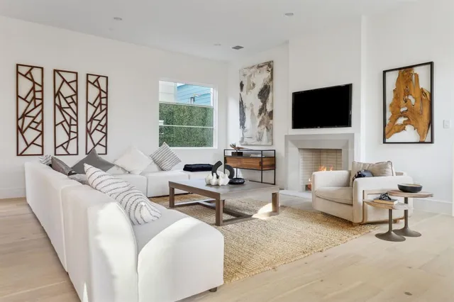 a living room with furniture a flat screen tv and a fireplace