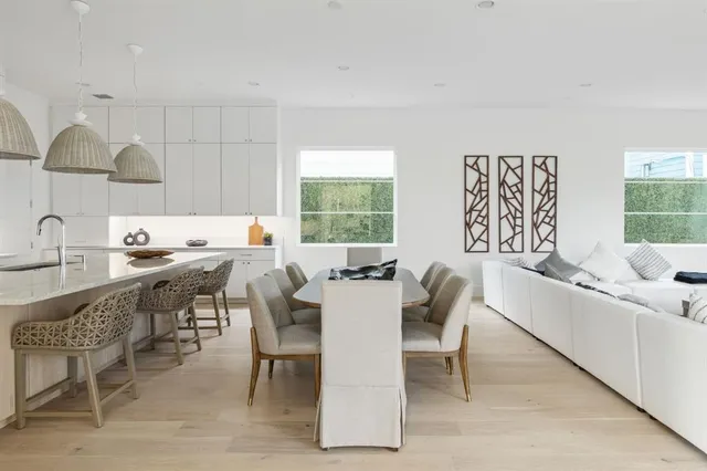 a kitchen with a dining table chairs and sink
