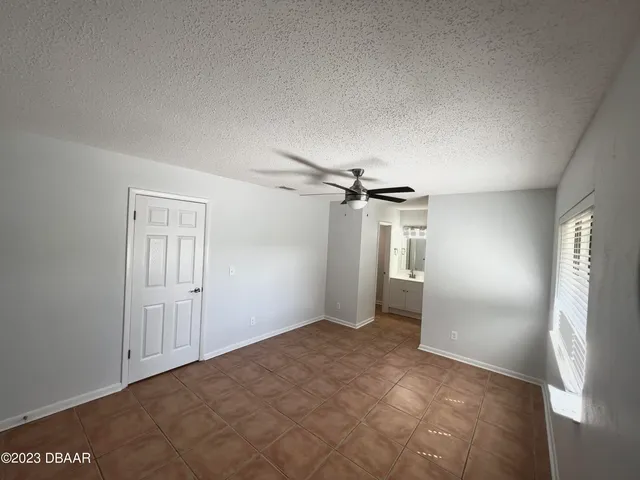 an empty room with closet and windows