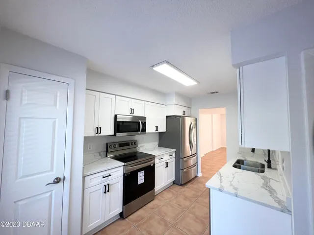 a kitchen with a refrigerator stove and sink