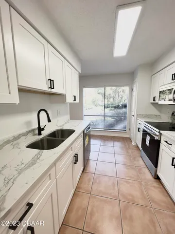 a kitchen with a sink a stove and cabinets