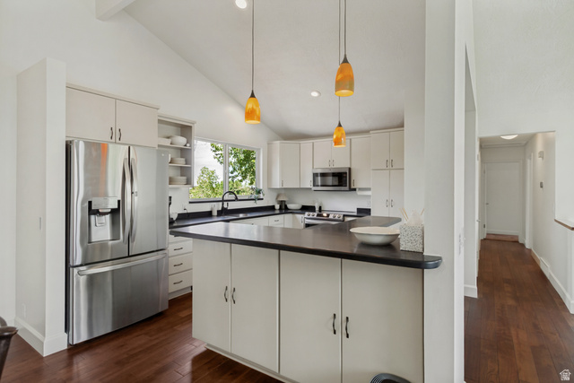 9706 Raintree Drive Sandy, UT 84092 - Photo 11 of 42 Vaulted ceiling with recessed lighting, stainless steel French door refrigerator, white cabinetry, dark countertops, and wood-finish flooring