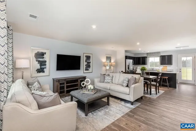 a living room with furniture kitchen view and a flat screen tv