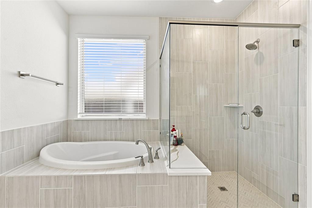 824 Blue Fescue Road Justin, TX 76247 - Photo 10 of 13 Built-in soaking tub with brushed nickel fixtures, tiled surround, and window with blinds