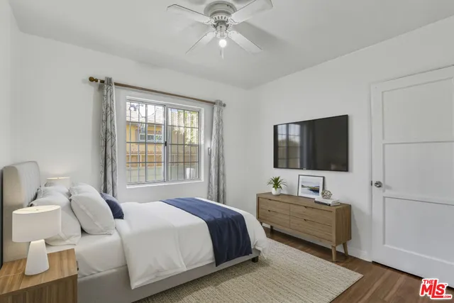 a bedroom with a bed and a flat screen tv