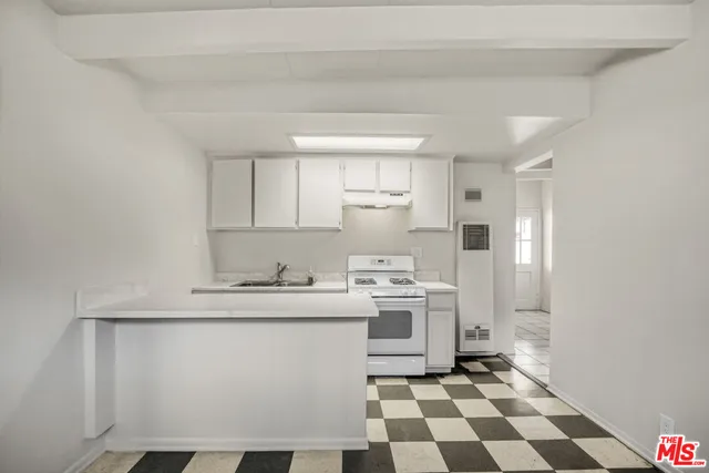 a kitchen with stainless steel appliances a sink a stove a refrigerator and cabinets