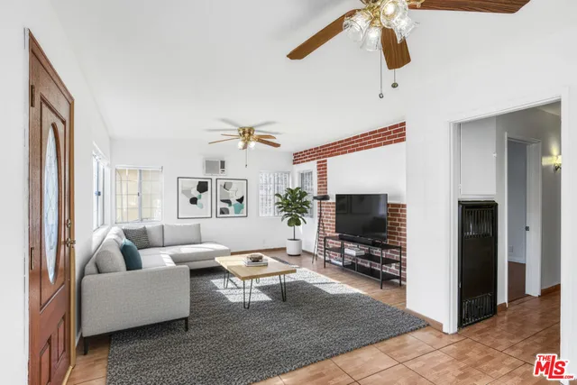 a living room with furniture a flat screen tv and a window