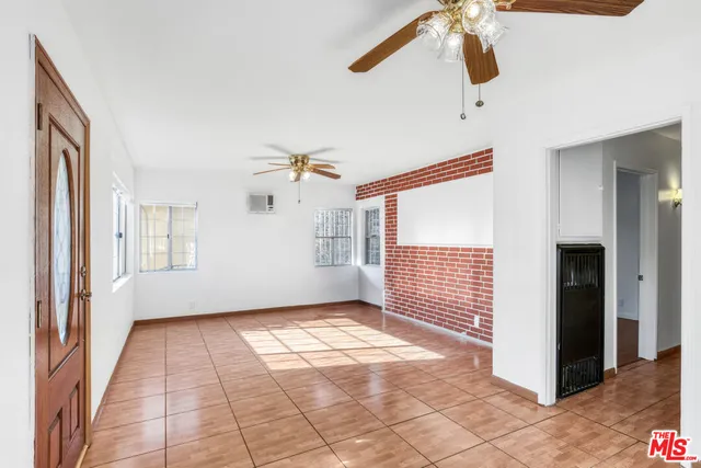 a view of a hallway with a chandelier fan and windows