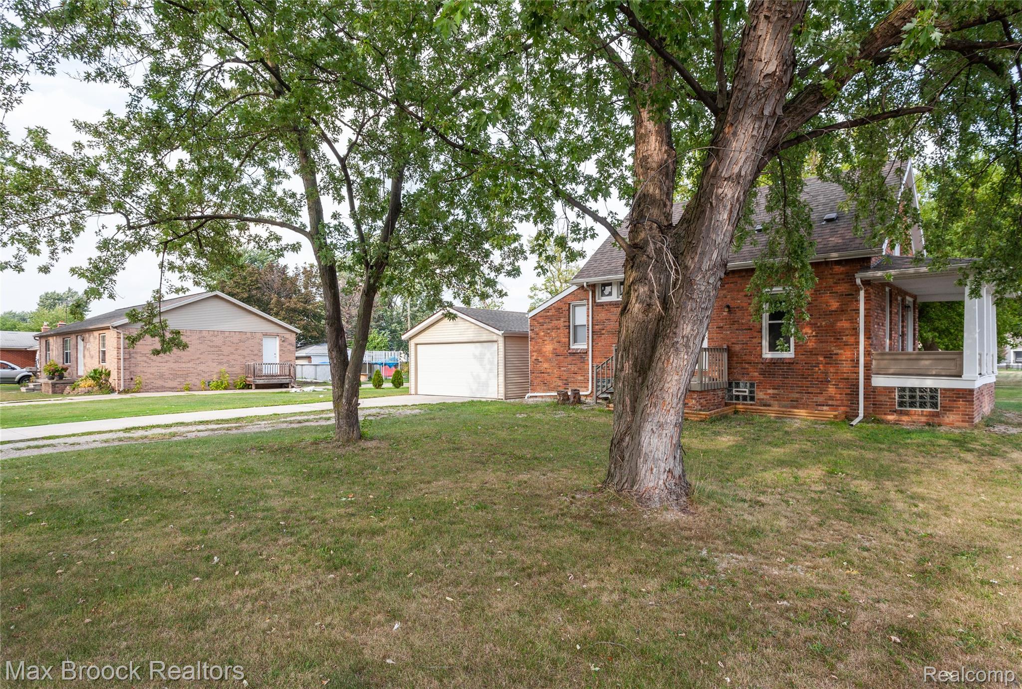 13071 East Thirteen Mile Road Warren, MI 48088 - Photo 23 of 23 View of property exterior featuring brick siding, a lawn, a shingled roof, and a garage