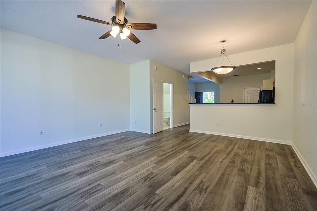 4116 Southwest 54th Circle Ocala, FL 34474 - Photo 11 of 36 a view of a kitchen with wooden floor and a ceiling fan