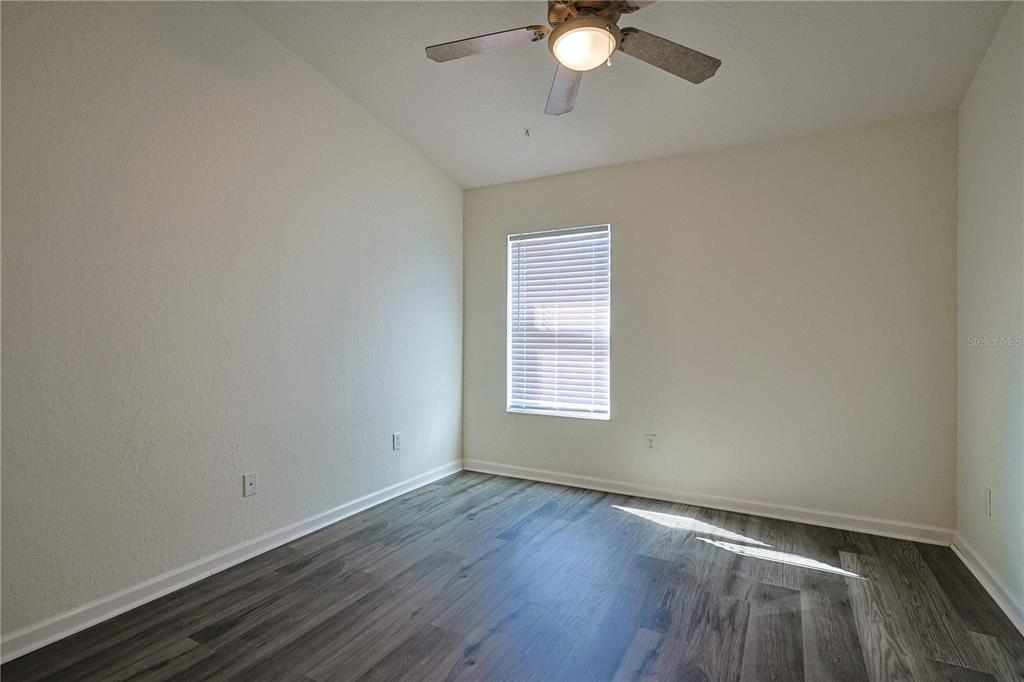 4116 Southwest 54th Circle Ocala, FL 34474 - Photo 21 of 36 an empty room with wooden floor fan and windows
