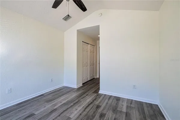 a view of an empty room with wooden floor