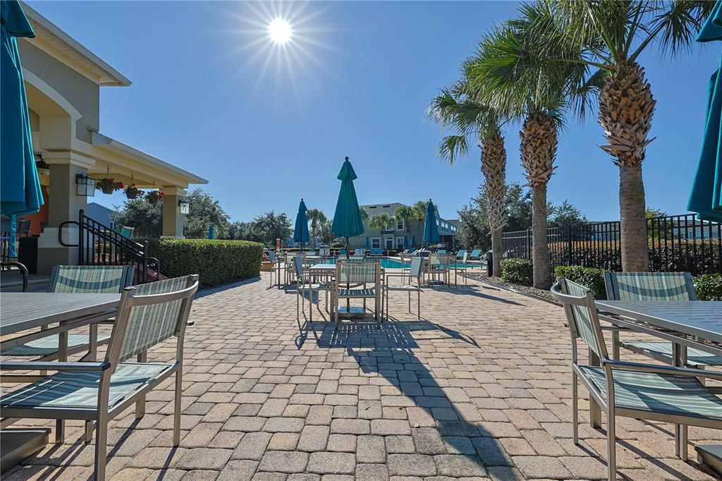 4116 Southwest 54th Circle Ocala, FL 34474 - Photo 30 of 36 a view of a patio with dining table and chairs with plants and palm trees